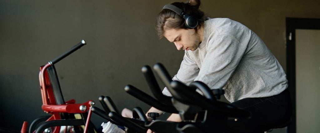 Man on a Bicycle at a Gym on Headphones