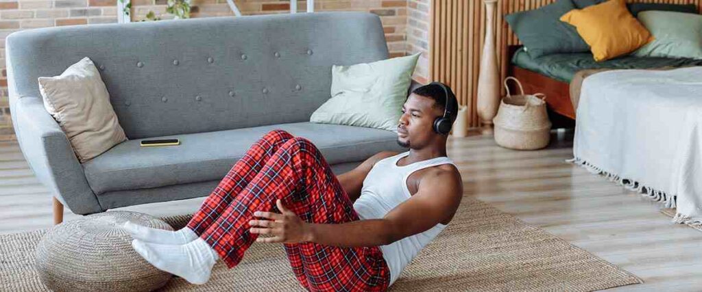 Man Wearing Headphones in Living Room While Working Out