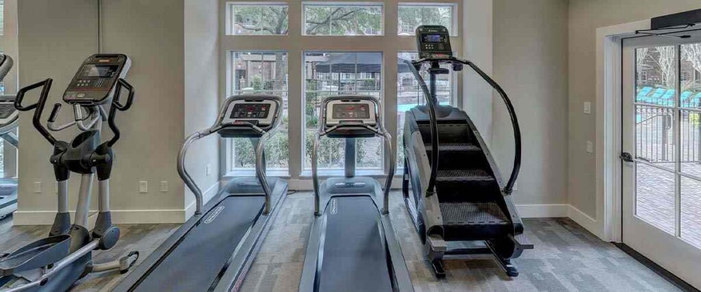 Inside of an apt gym with different types of treadmills
