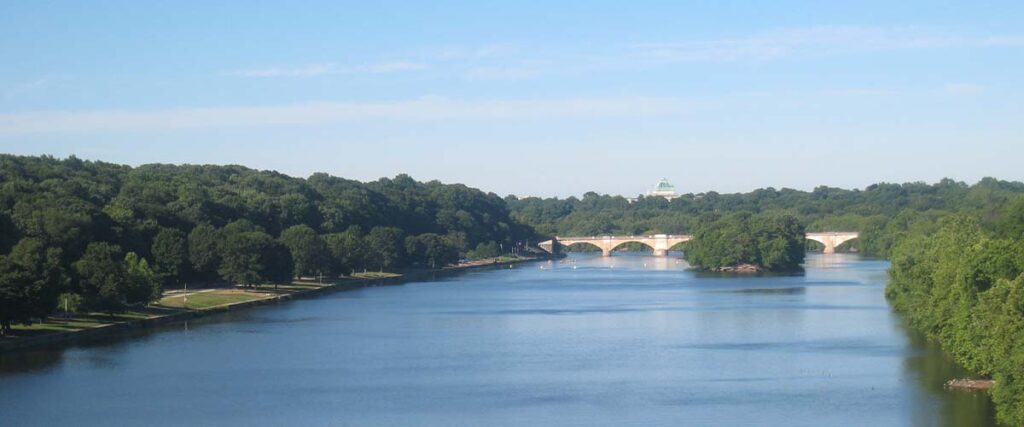 Boxers trail from afar with emphasis on lake and its bridge.