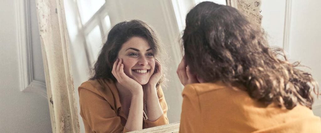 Woman smiling in the mirror.