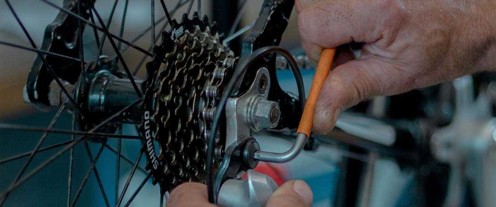 Man working on biking gears with tools.
