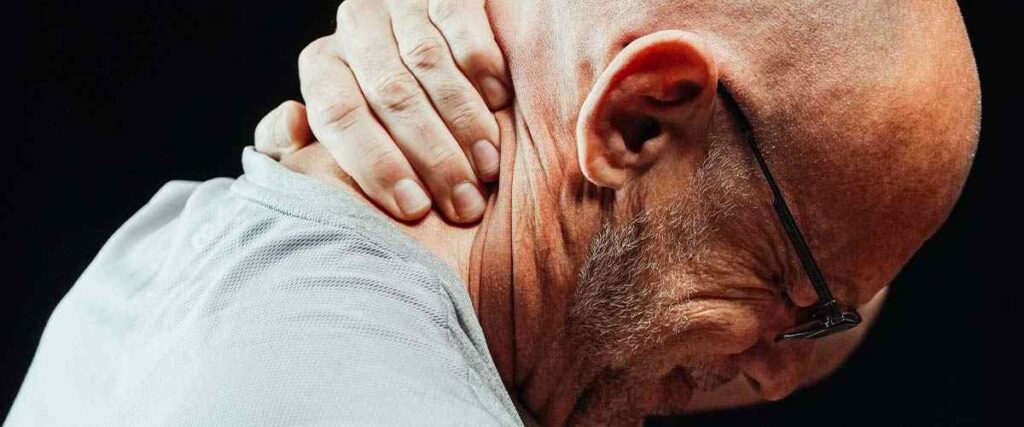 Man holding neck in pain.