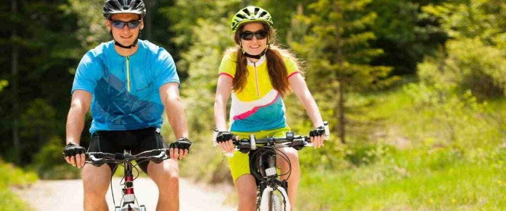 Two cyclists smiling on bike trial.