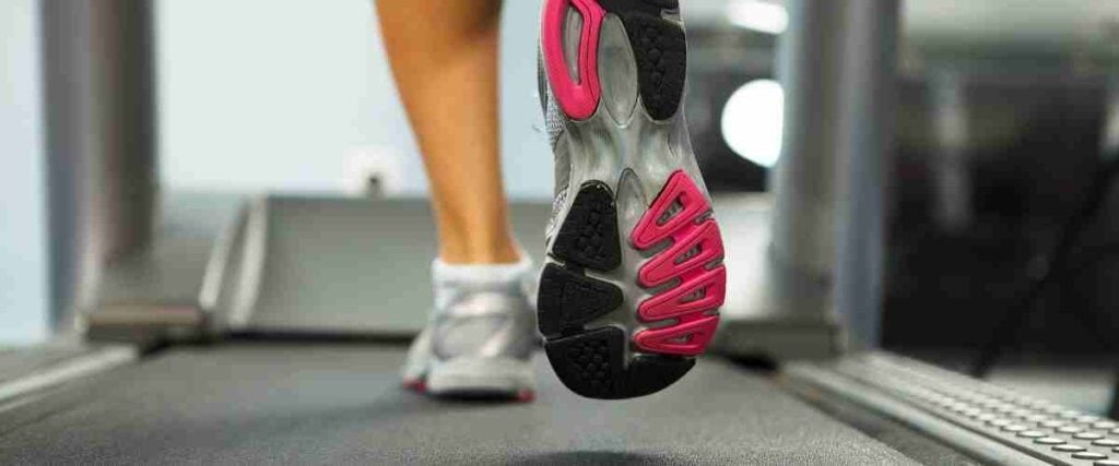View of bottom of running shoe of woman running on a treadmill. 