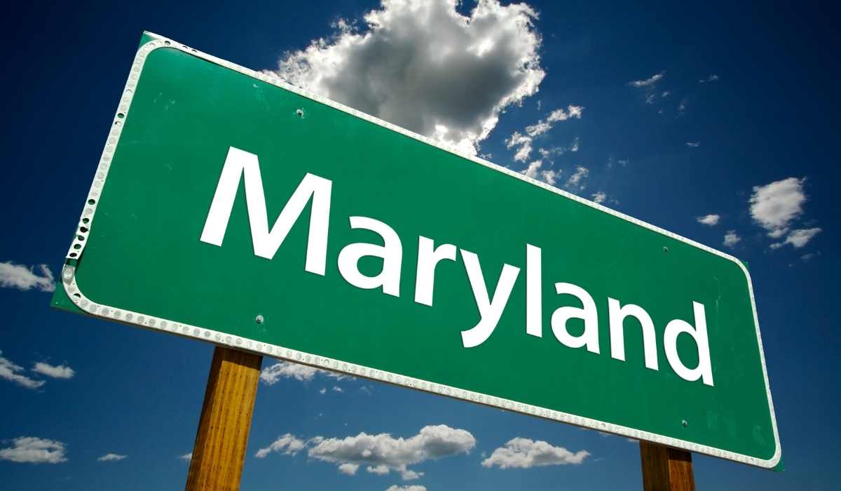A big green sign against big blue sky with 'Maryland' written on it. 