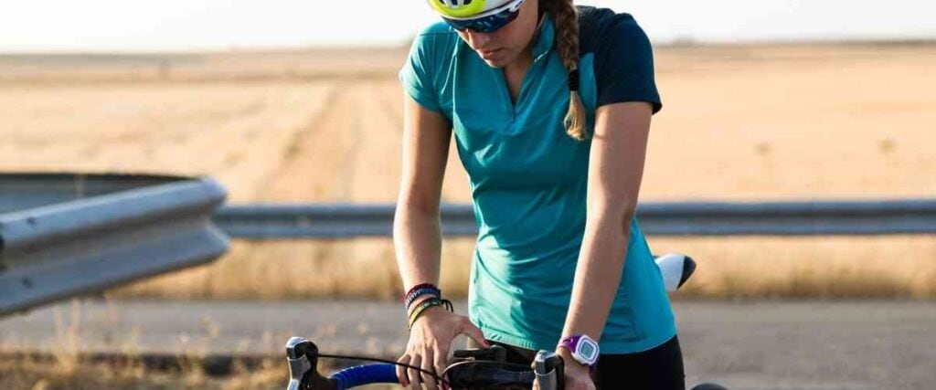 Female cyclists setting up bike to track performance. 