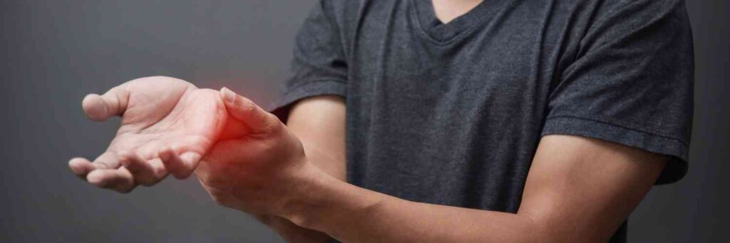 A man holding his wrist with a red area that emphasizes where it hurts. 