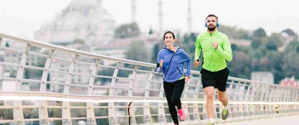 Man and woman running on a bridge together. 