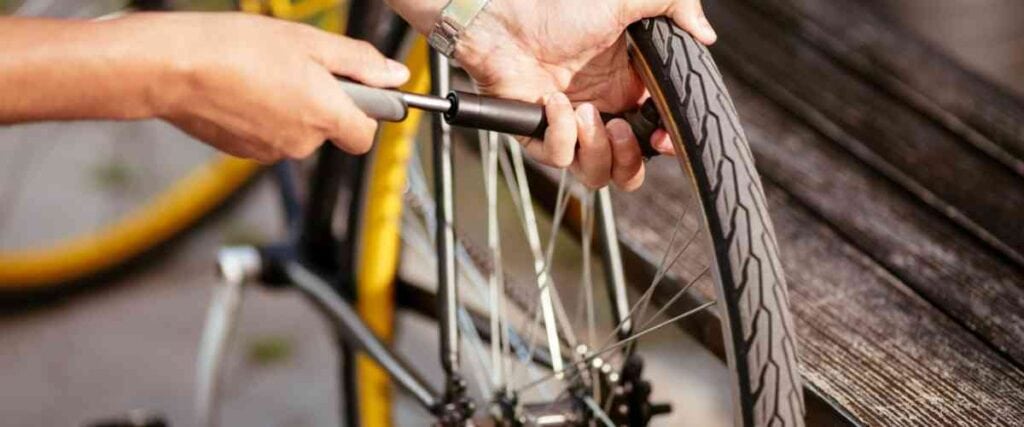 Man pumping his back bike tire with air.