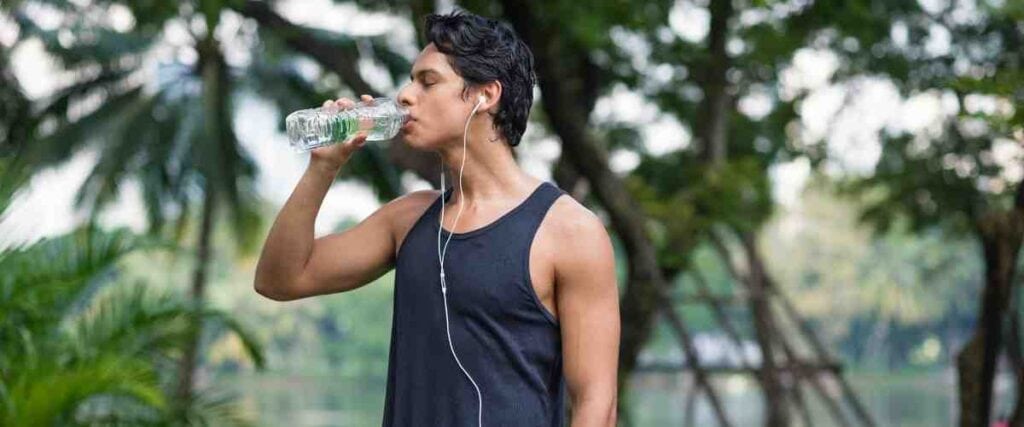Man drinking water after his run. 