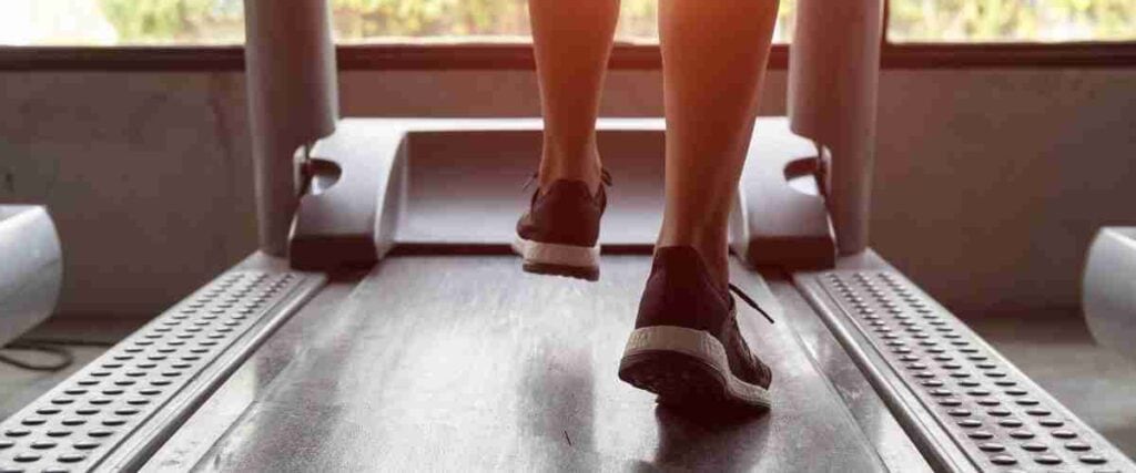 Woman running on treadmill indoors. 