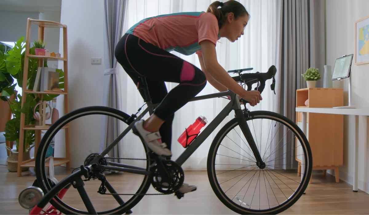 A woman on her indoor bike trainer watching her tv during a workout. 