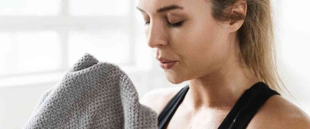 Woman sweating about to wipe away the sweat off her face.