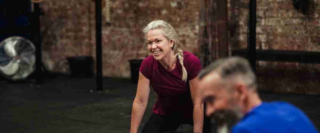 Man and woman smiling while in the gym.