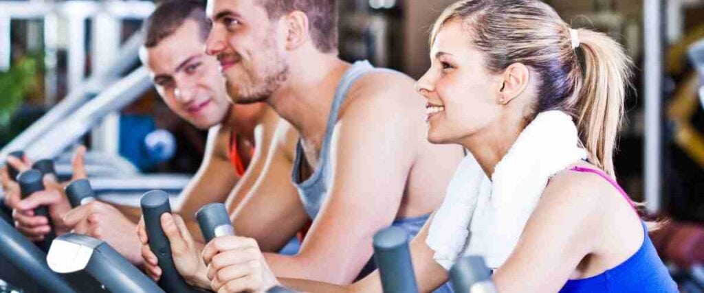 A group of people in a gym on indoor bikes.
