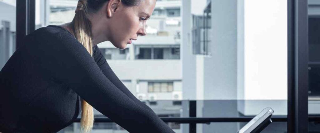 Female cyclists looking down on indoor bike in her high rise.