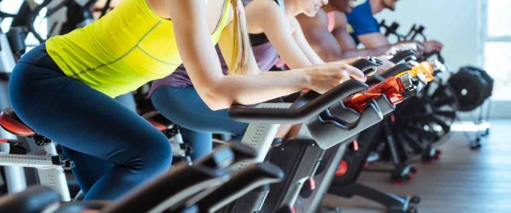 A group of cyclists in a gym mid cycle.