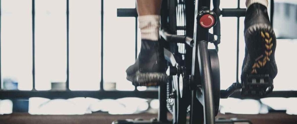 Close up of male cyclists on indoor bike and bike stand.