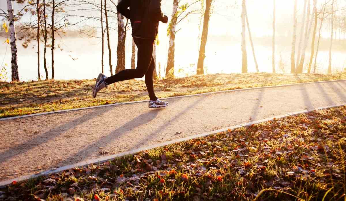 Woman running in the park during sunrise. 