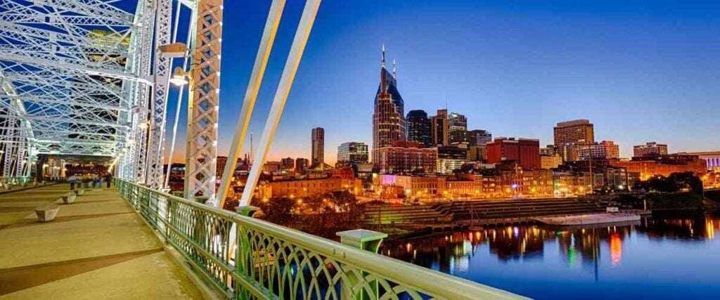 View of downtown Nashville at night on a bridge. 