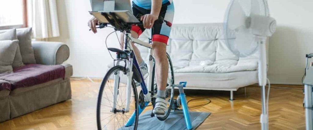 A male cyclist setup his bike in living room while virtual cycling. 