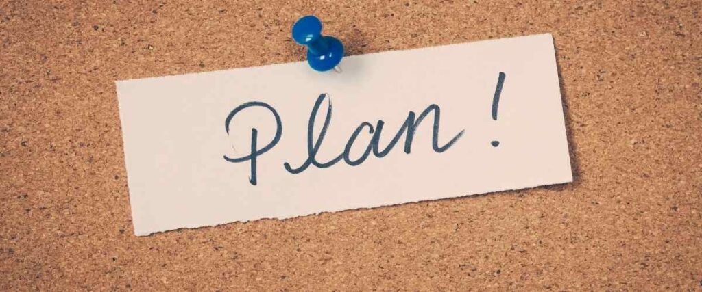 Paper with tacked to a board with the word 'Plan!' written on it.