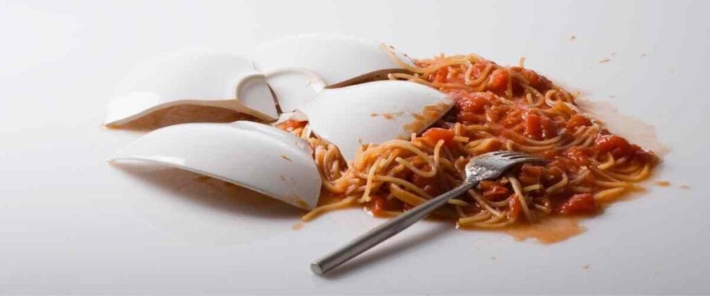 A broken dish of spilled spaghetti. 