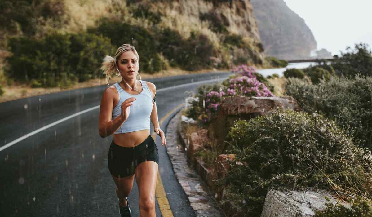 Female runner turning the corner on a rocky road.