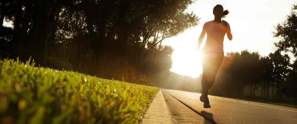 Woman running during sunrise. 