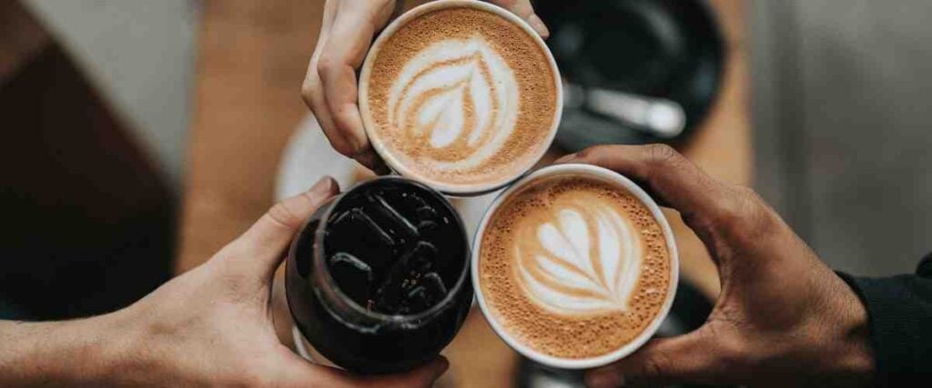 3 different cups of coffee being cheered.