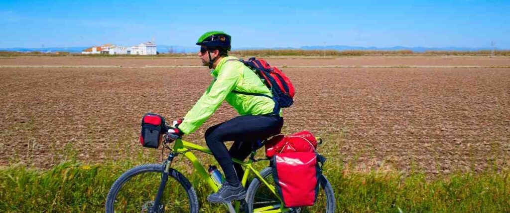 Man doing a bike tour with his bike packed with supplies for his trip.