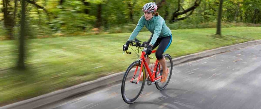 Female cyclist bundled up on road.