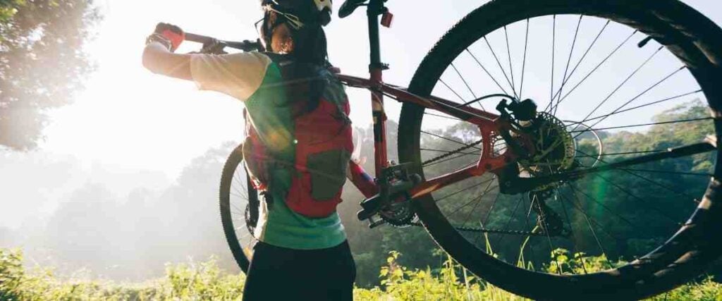 Cyclists holding bike with close up to back wheel.