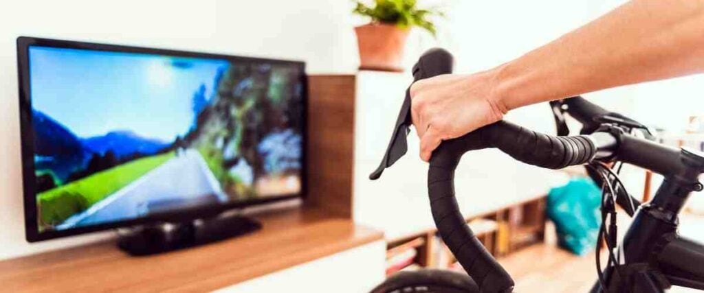 Cyclist riding indoors with Vingo on TV.