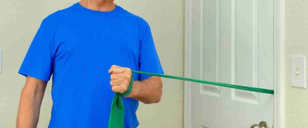 Man using resistance bands in door frame. 