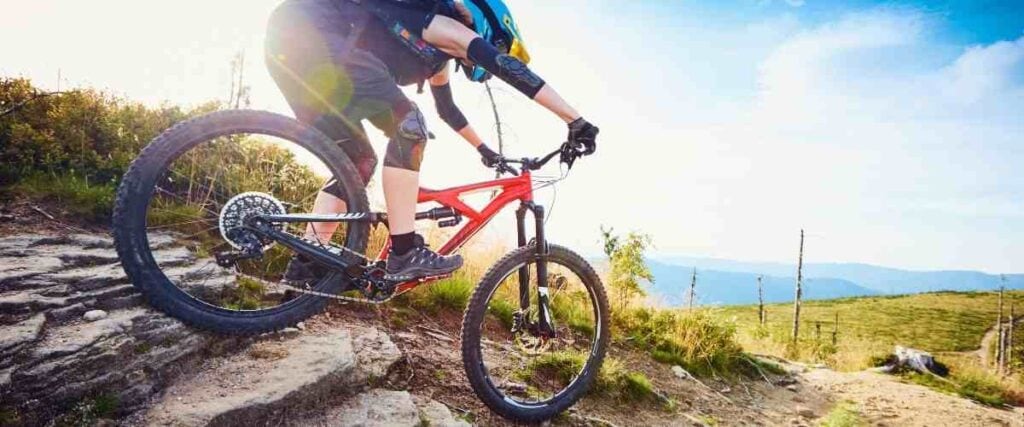 Mountain biker going down steep hill.