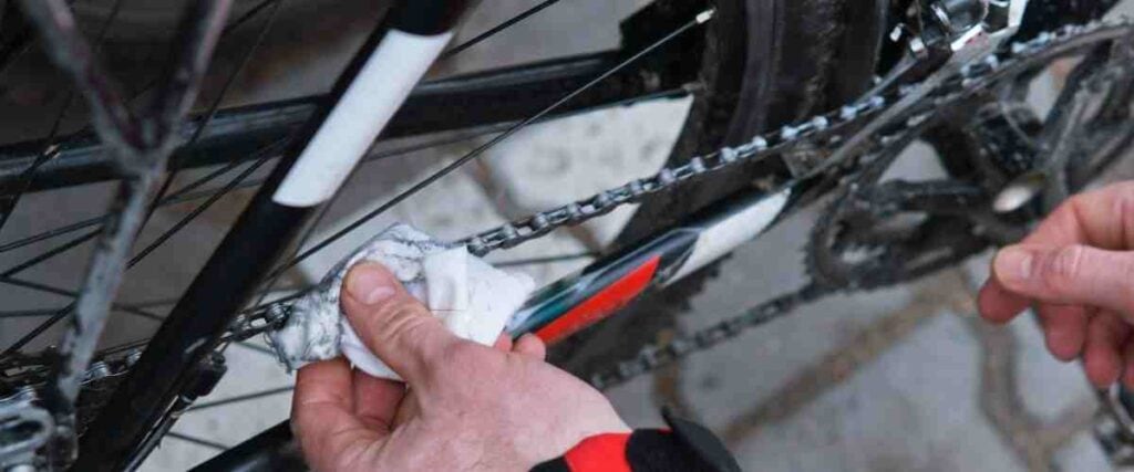 Cyclists cleaning bike chain. 