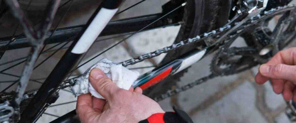 Cyclists cleaning bike chain.