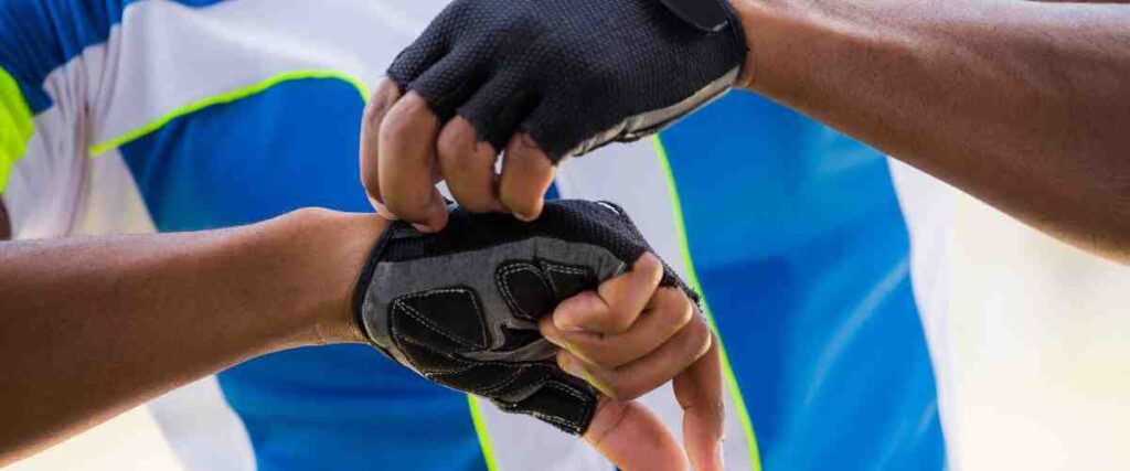 A cycling putting on his cycling gloves before a ride. 