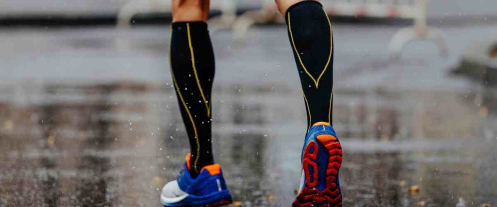 Male runner wearing compression socks in the rain. 