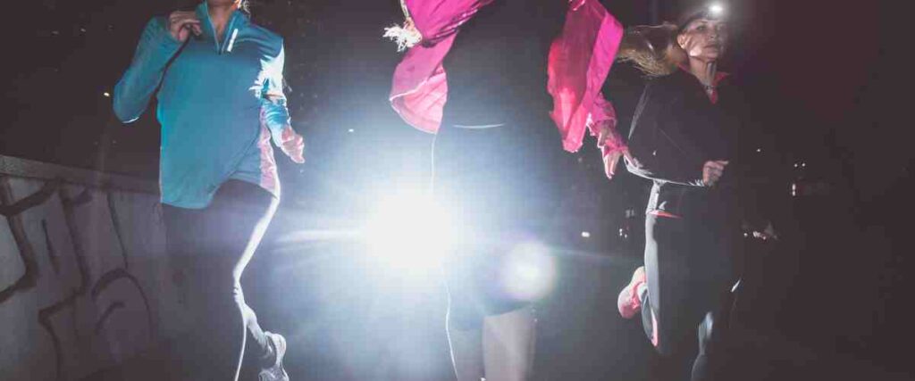 Group of female runners, one with a headlamp on.