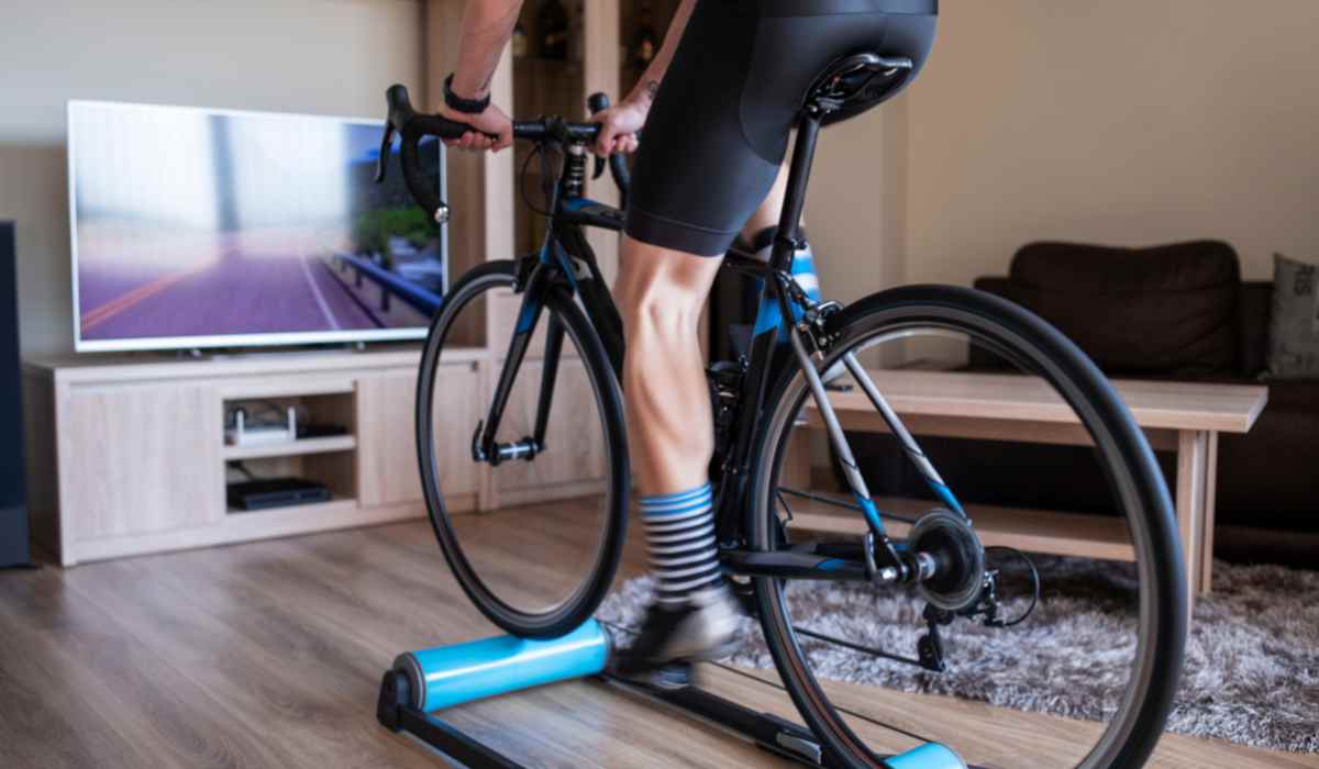 View of male cyclists on his indoor bike at home working out while watching tv.