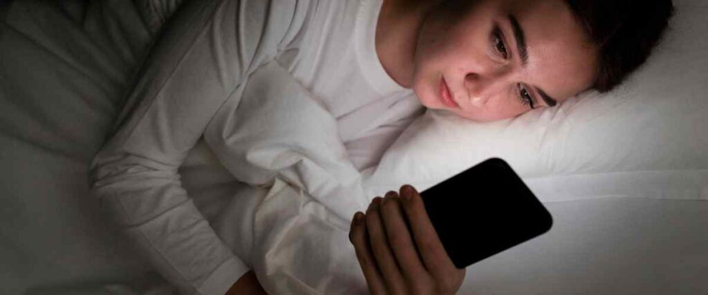 Woman on her phone in bed. 