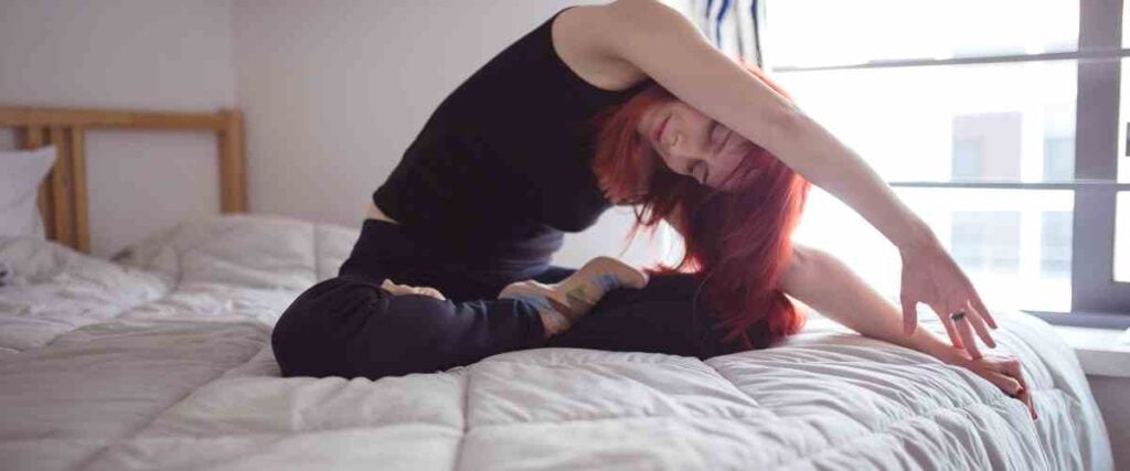 Woman streching on her bed. 