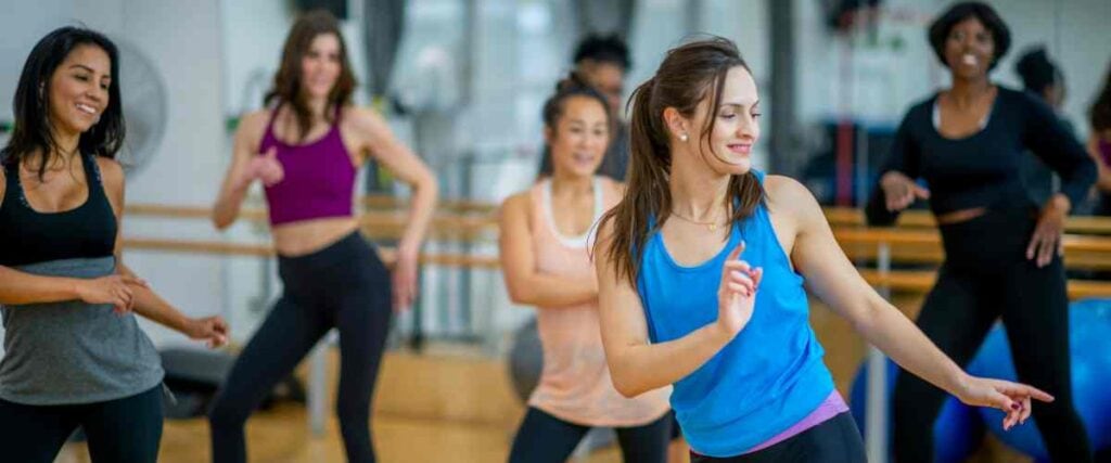 Women at a gym taking a dance class having fun.
