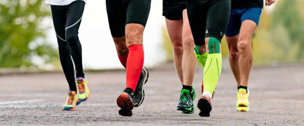 A group of runners wearing compression shots with the view of looking at just their legs. 