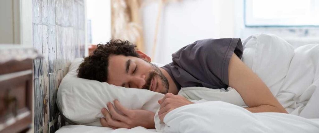 A man sleeping in his bed. 