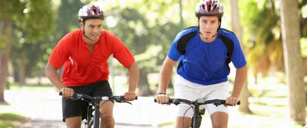 Two male cyclists riding side by side.
