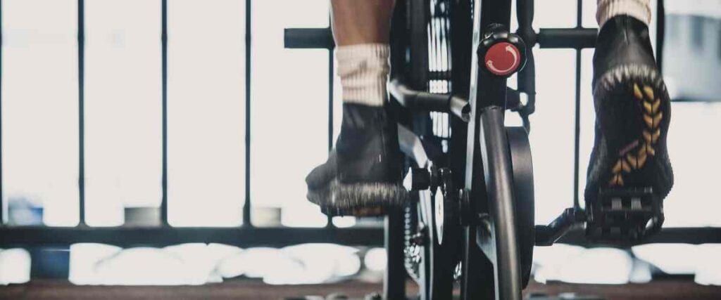 View of a cyclists on his indoor trainer from behind.
